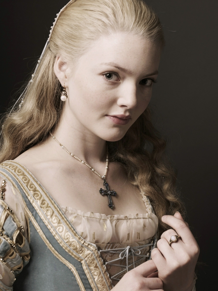 elizabethan hairstyles, blonde young woman, with hair tied back at the top, and let to fall in curls at the bottom, wearing renaissance dress, and a crucifix necklace