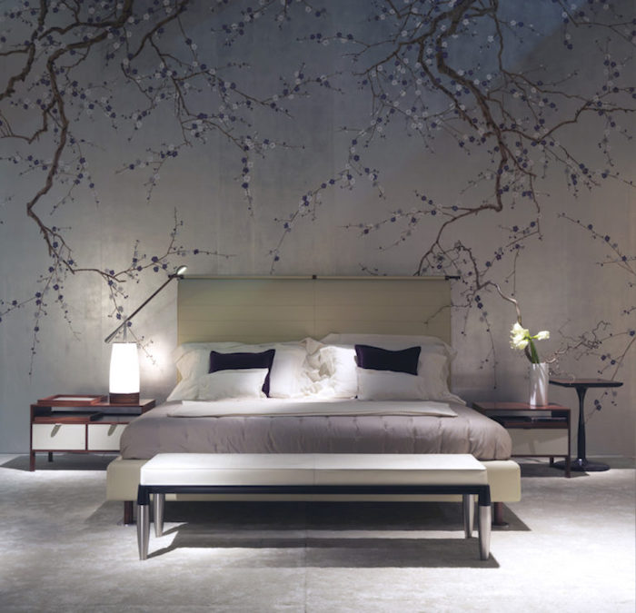 mural depicting tree branches in blossom, on a pale gray wall, near cream-colored bed, bedroom wall decor, white bench and two-tone bedside tables