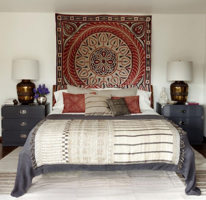 mandala in red, dark gray and pale beige, on a square rug, hanging over a bed in matching colors, bedroom design, two identical gray bedside cupboards