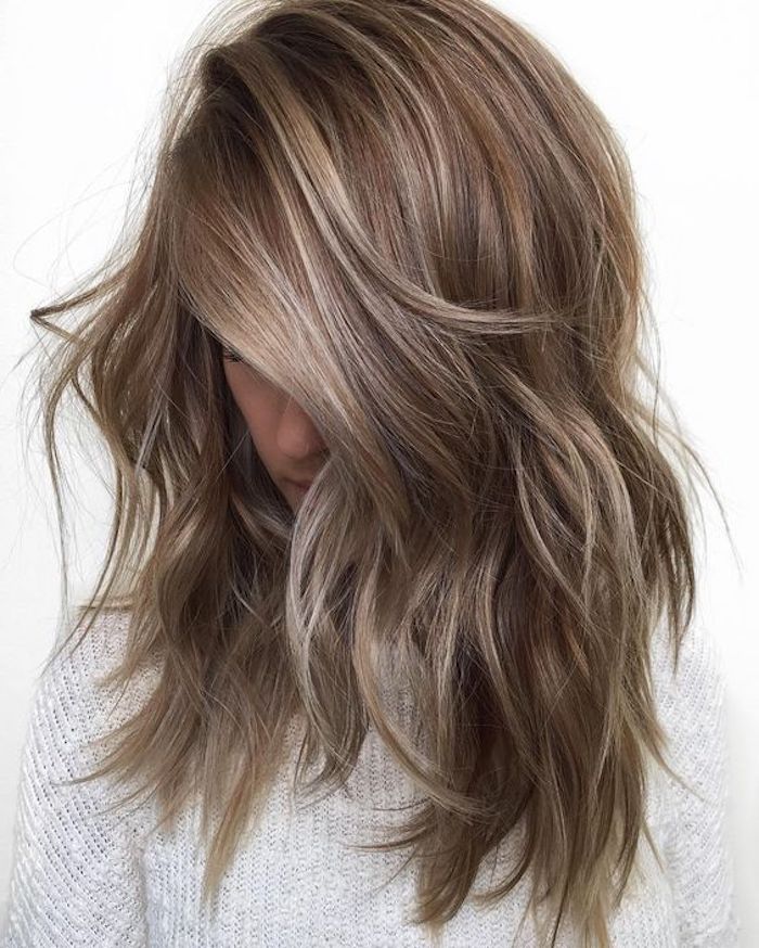 medium brown hair, layered and messy, falling over a young girl's face and hiding it, with ash blonde highlights