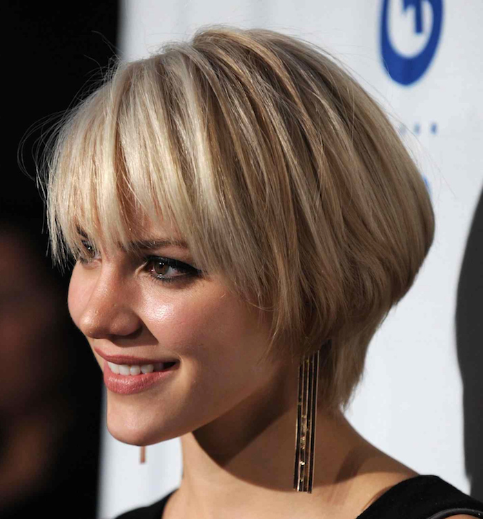 eye pencil in black, and discrete make up, on smiling blonde woman, with bowl-like haircut, and side bangs, short haircuts for fine hair, black top and long earrings