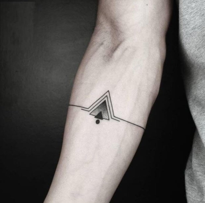 lines and triangles, in black and grey, and a single black dot, symmetrical cool arm tattoos, on the inside part of a man's arm, just below the elbow