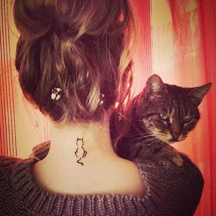 cat tattoo on the neck, angry cat, tattoos for women with meaning, brown hair in a bun, grey blouse
