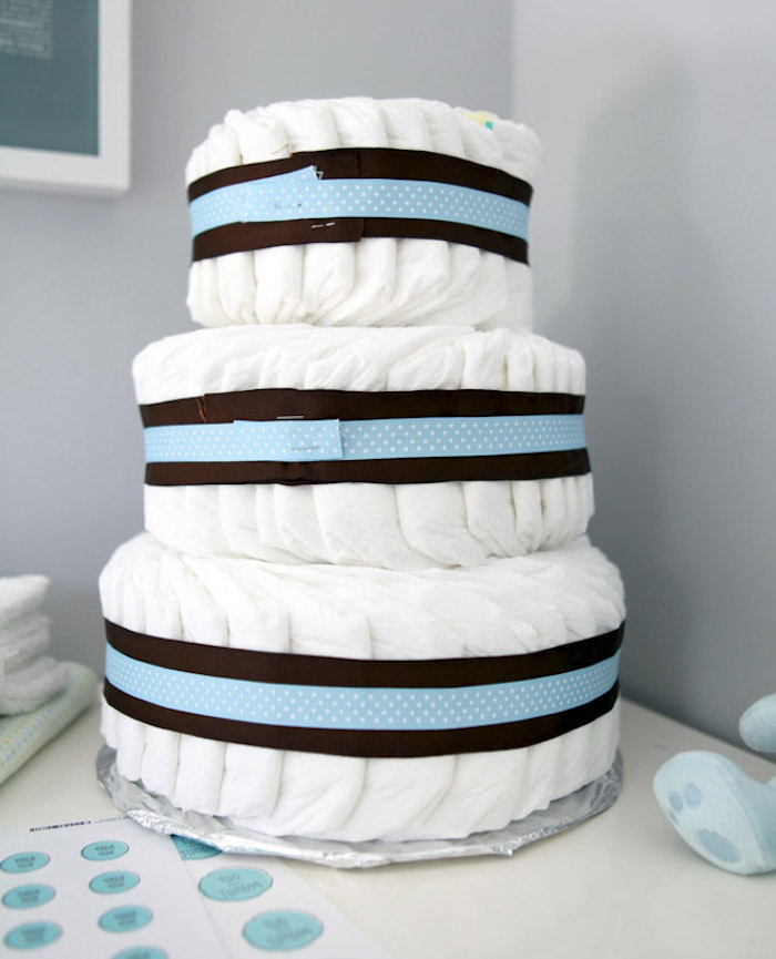 baby shower themes, three tied diaper cake, black and blue ribbon, grey wall background