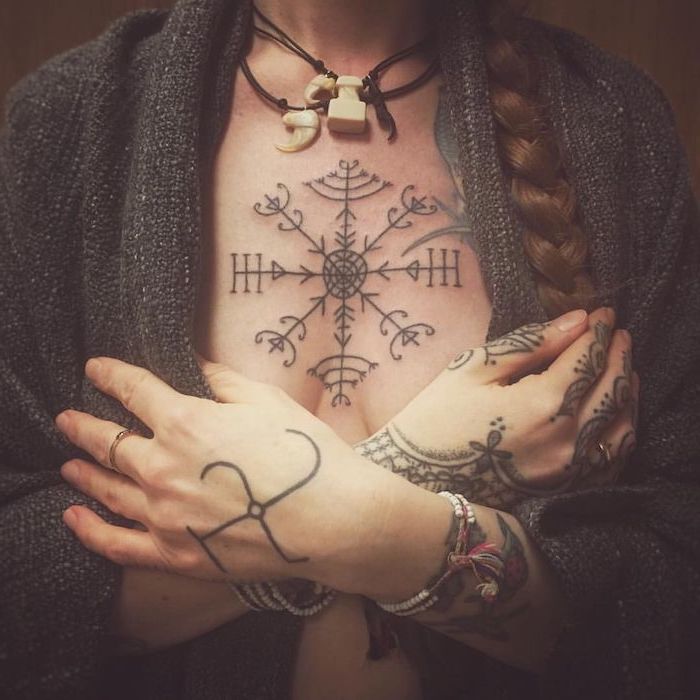 tattoos for women, dark grey cardigan, symmetrical tattoo with arrows, braided brown hair