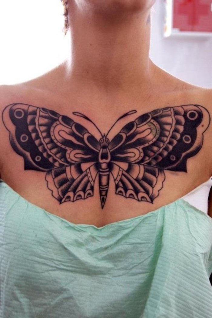 tattoos for women with meaning, large black butterfly, green paper, white top and background