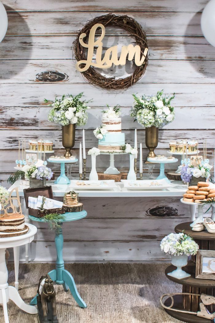 flower bouquets in vases, cake and sweets on the table, baby shower themes for boys, wooden backdrop