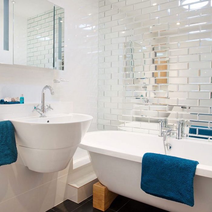 small bathroom layout, mirror tiled wall, floating white sink and bathtub, small mirror, white wall