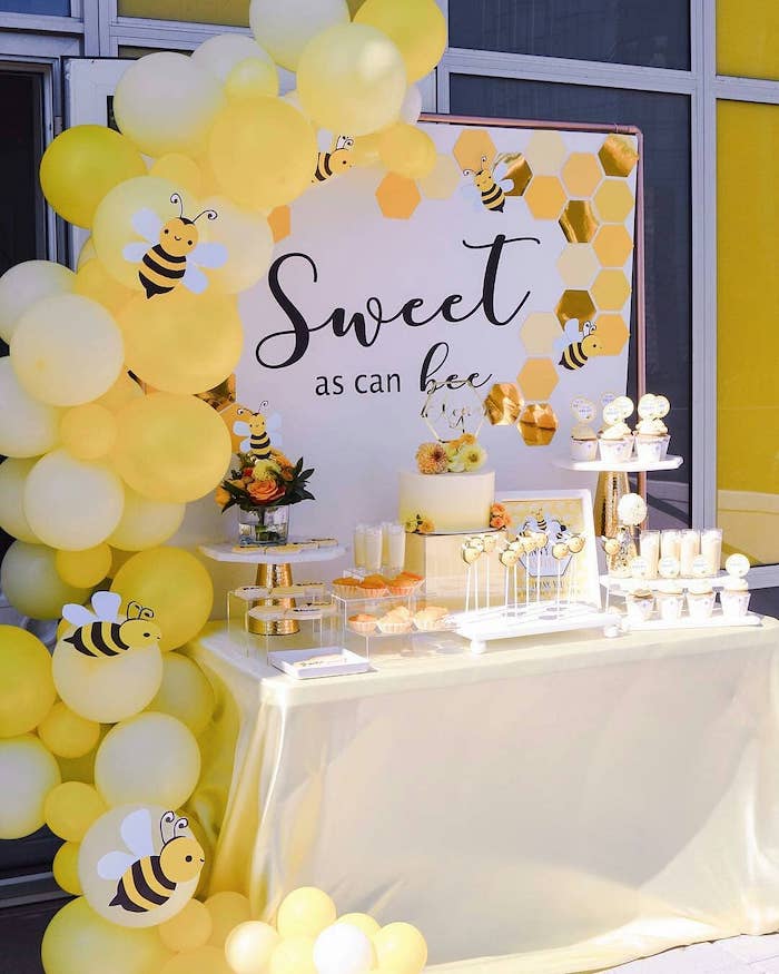 sweet as can bee banner, yellow balloons, paper bees, unique boy baby shower themes, cake and sweets on the table