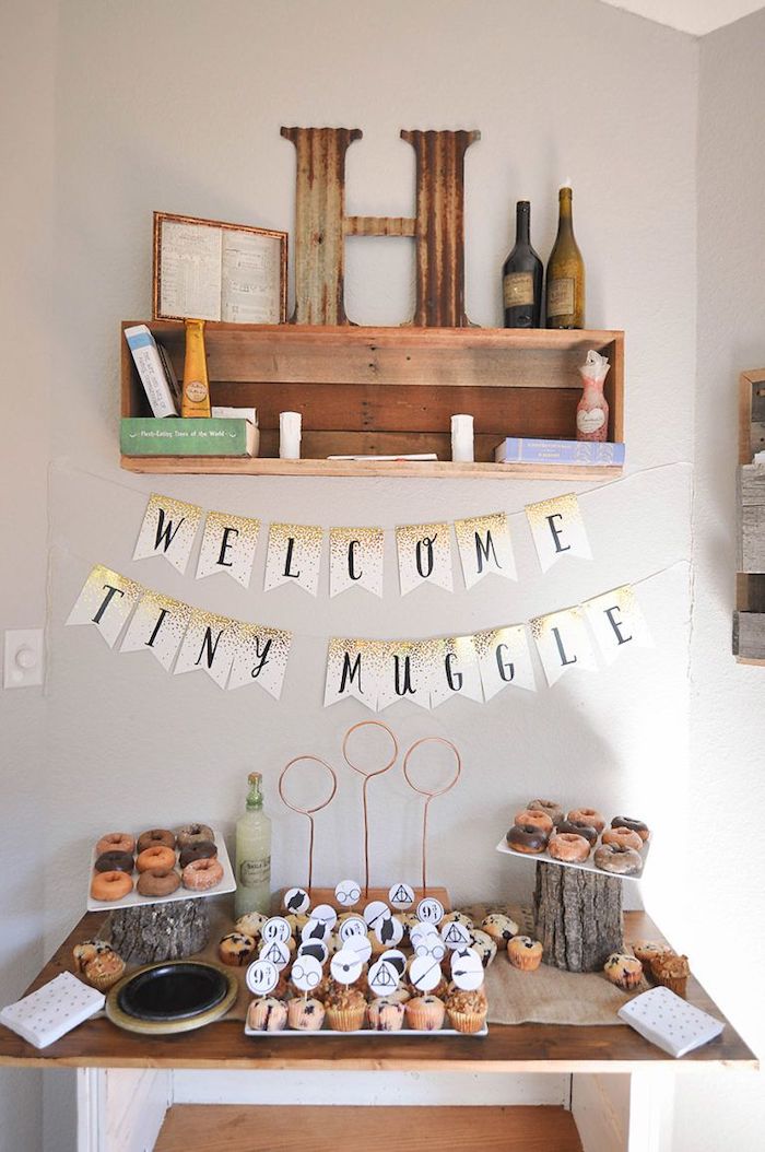 welcome tiny muggle banner, cupcakes and donuts on the table, baby shower ideas for boys