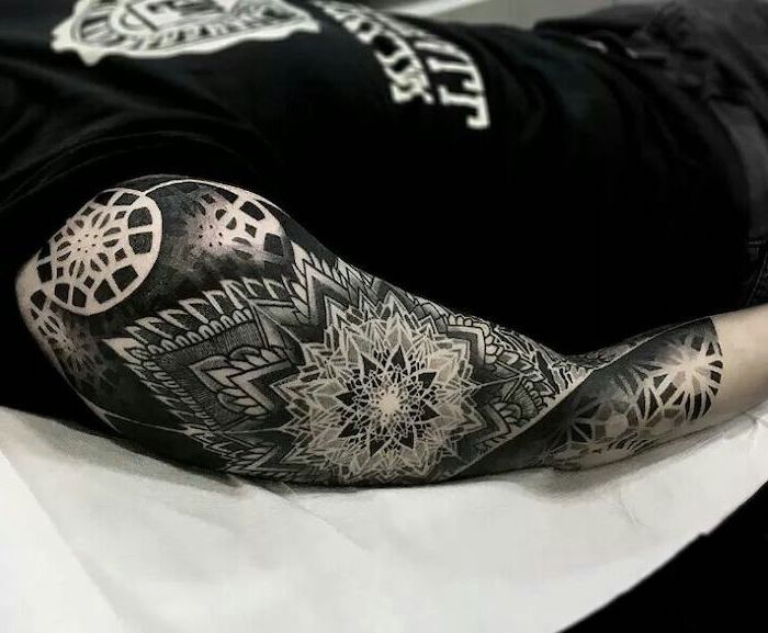 black and white, arm sleeve tattoo, tattoo designs for men, man lying on a table, dressed in all black
