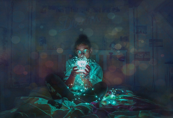 girl sitting on a bed, holding fairy lights, black and white tumblr