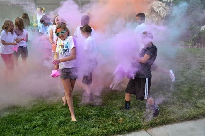 colourful smoke, children playing around, on green grass, birthday party themes, blue and purple smoke
