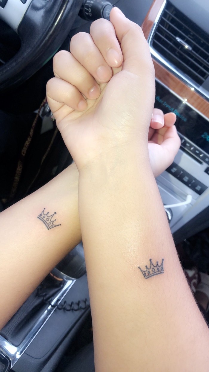small crowns, forearm tattoos, matching friend tattoos, photo taken inside the car
