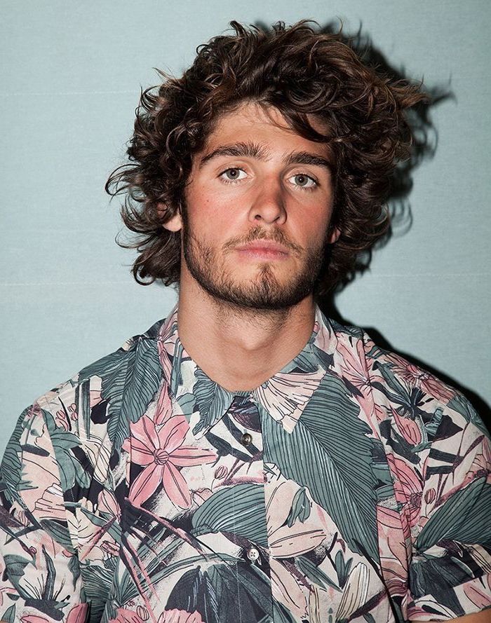 floral shirt, black curly hair, medium hairstyles for men, blue background
