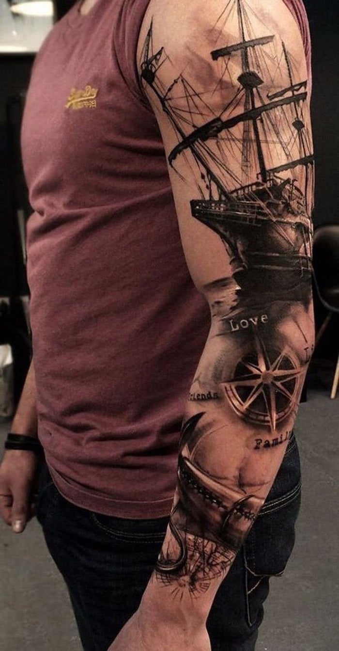 red top, forearm sleeve tattoo, black jeans, ship and compass