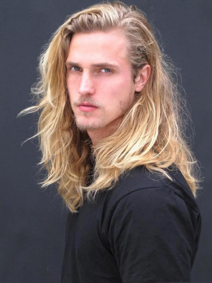 blonde wavy hair, hairstyles for men with thick hair, black shirt, grey background