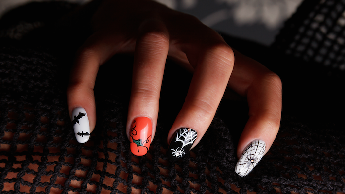 orange and black, white nail polish, black bats, spider web decorations, squoval nails, halloween nail ideas