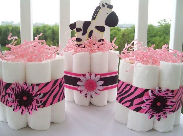 diapers arranges together, with a pink ribbon, girl baby shower, white table