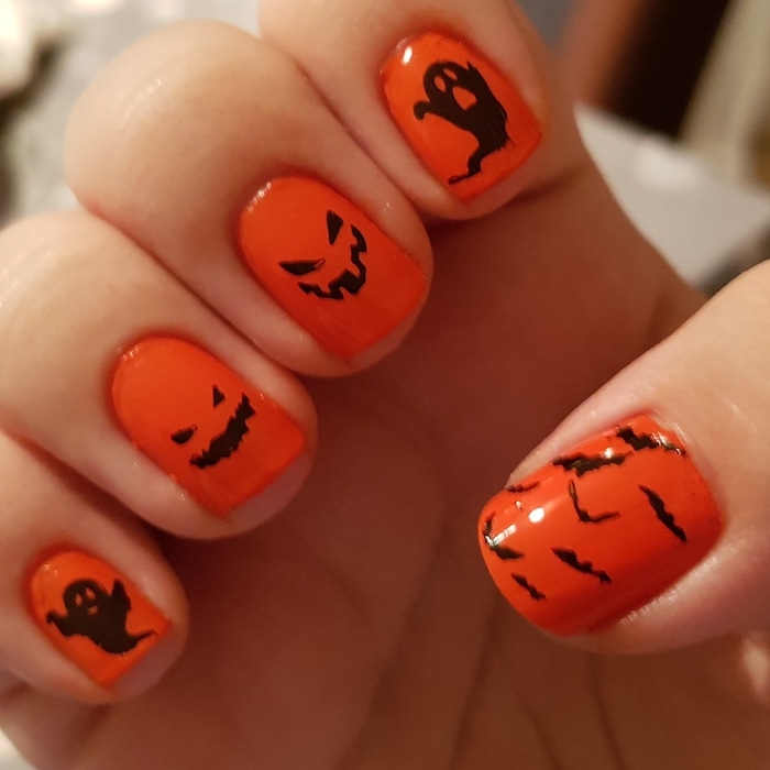 cute halloween nails, orange nail polish, black decorations, ghosts and bats, short squoval nails