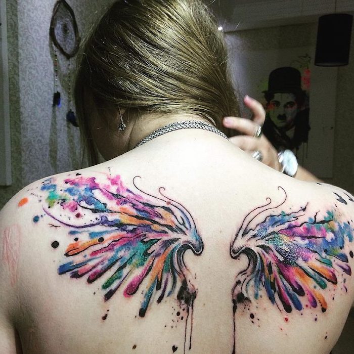 watercolor tattoo, back tattoo, woman with blonde hair, wings neck tattoo, blurred background