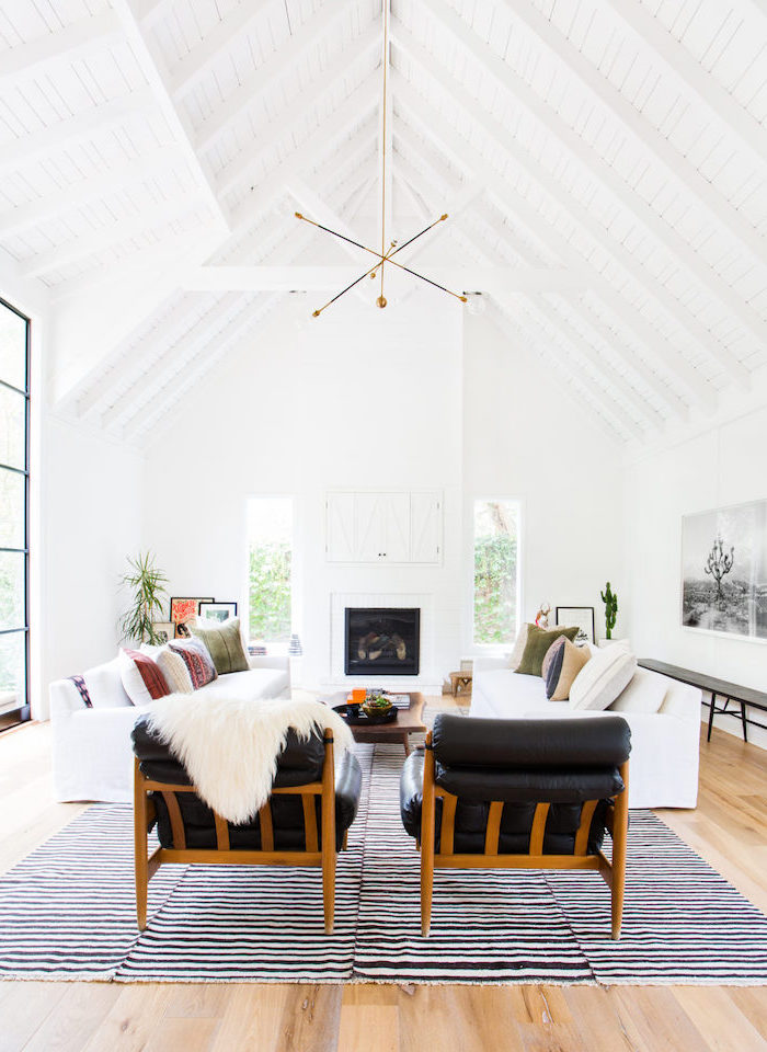 black leather armchairs, white sofas, black and white carpet, vaulted ceiling, wooden floor