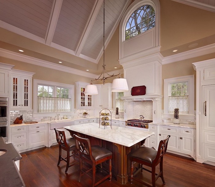 marble kitchen island, white cupboards, what does vaulted mean, wooden floor, wooden chairs