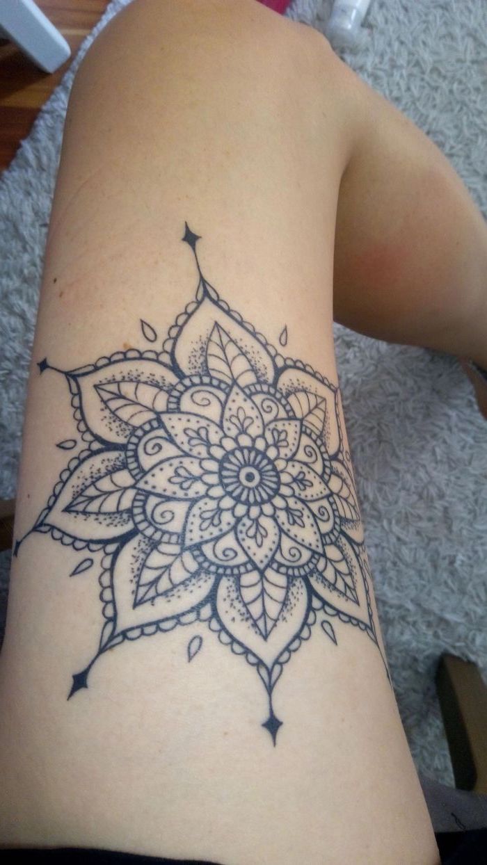 thigh tattoos for girls, mandala flower tattoo, white carpet, wooden floor