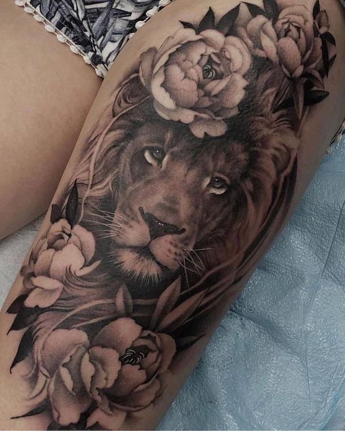 lion head, surrounded by flowers, leg tattoos for women, black and white shorts