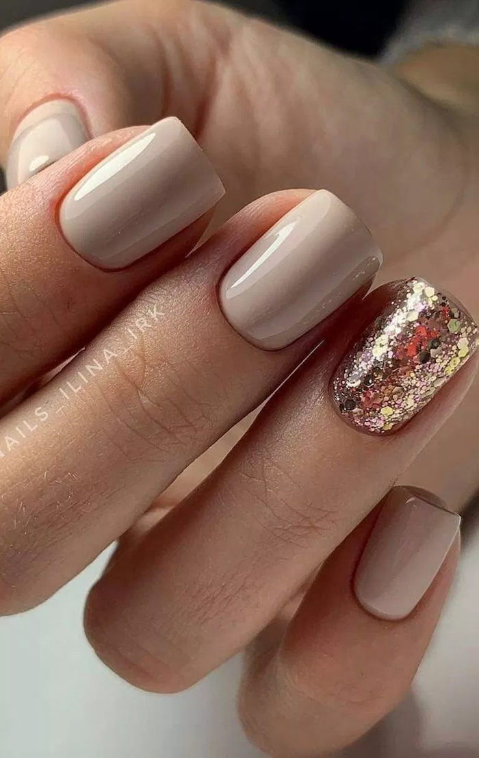 nude nail designs, gold glitter nail polish on the ring finger, short square nails