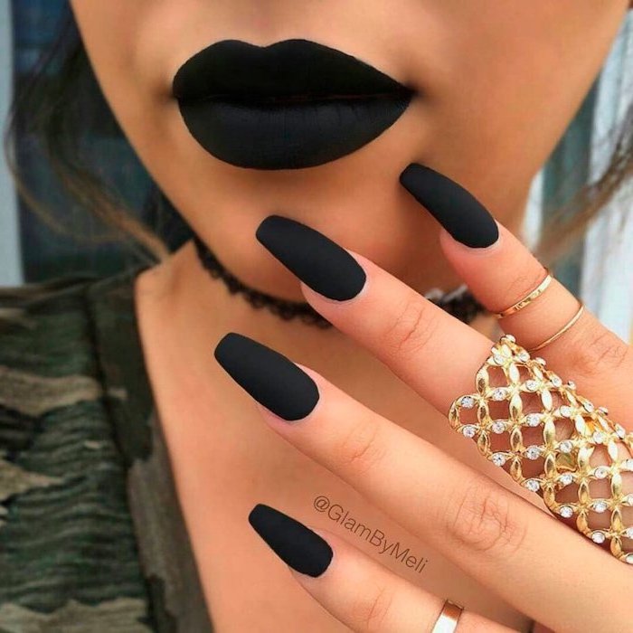 woman with black matte lipstick, long nails with black matte nail polish, white and gold nails, large golden ring
