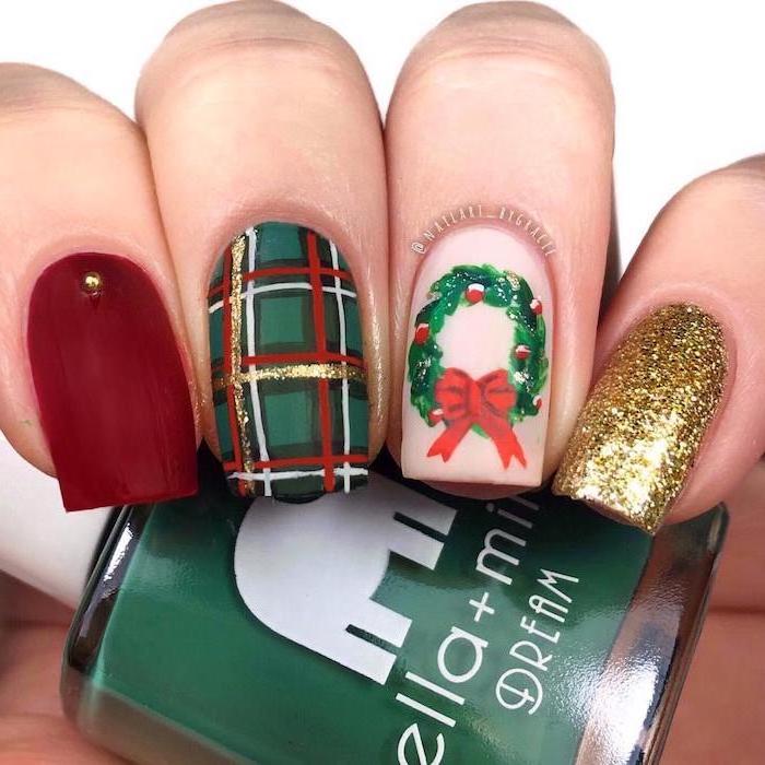 christmas theme decorations on each nail, different color nails, red green and gold glitter nail polish, wreath decoration on ring finger