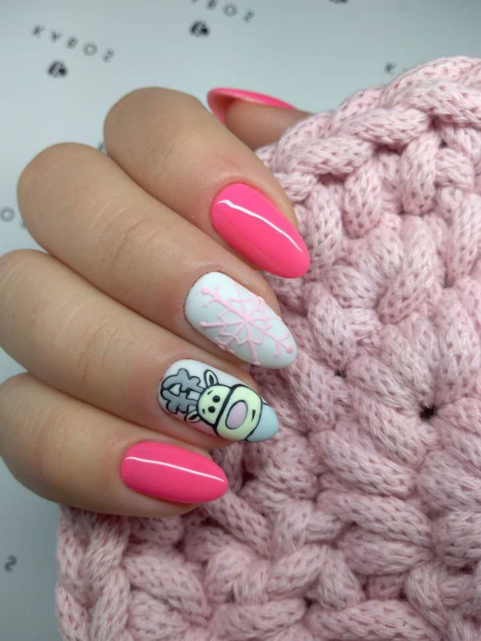 pink and white nail polish, reindeer decoration on ring finger, snowflake decoration on middle finger, nude nail designs