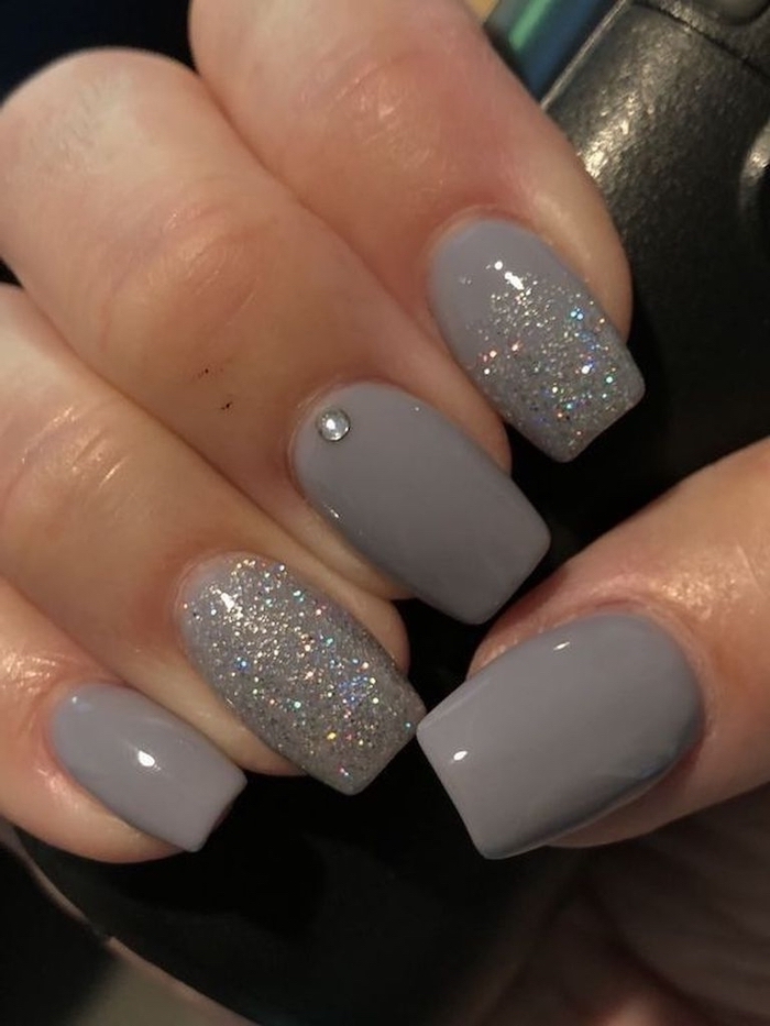 grey nail polish, silver glitter on index and ring finger, popular nail colors, medium length squoval nails
