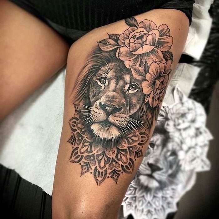 lion head, surrounded by flowers, mandala tattoo, lion thigh tattoo, on woman with black shorts