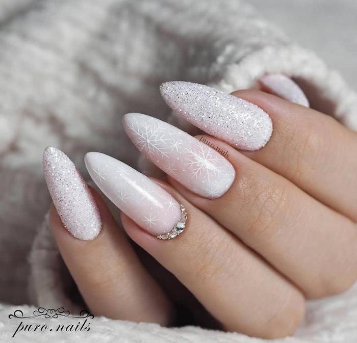 white glitter nail polish, snowflakes and rhinestones decorations on the middle and ring finger, january nail colors, long stiletto nails