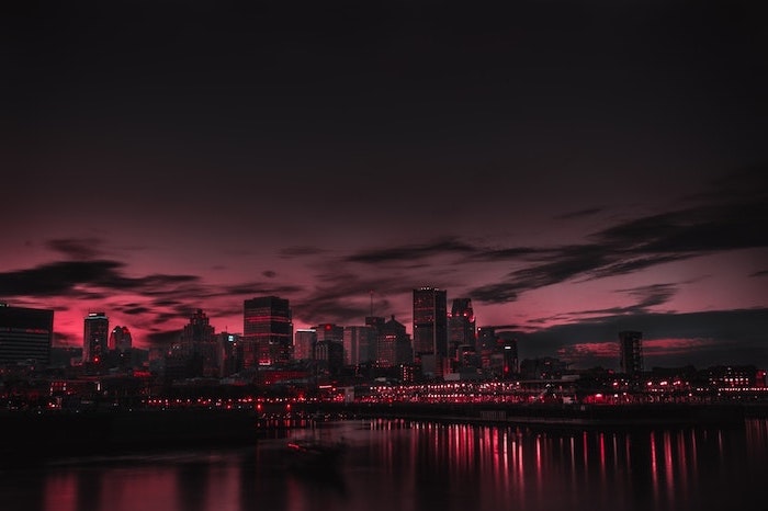 city skyline, photographed just after sunset, aesthetic desktop wallpaper, lights illuminated in the ocean