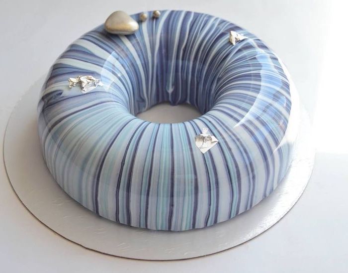 donut cake, covered with blue purple and white glaze, mirror glaze recipe, gold decorations on top, placed on white tray