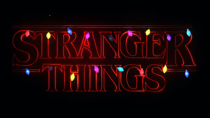 title of the show written in red neon, colorful string lights around it, black background, stranger things wallpaper iphone